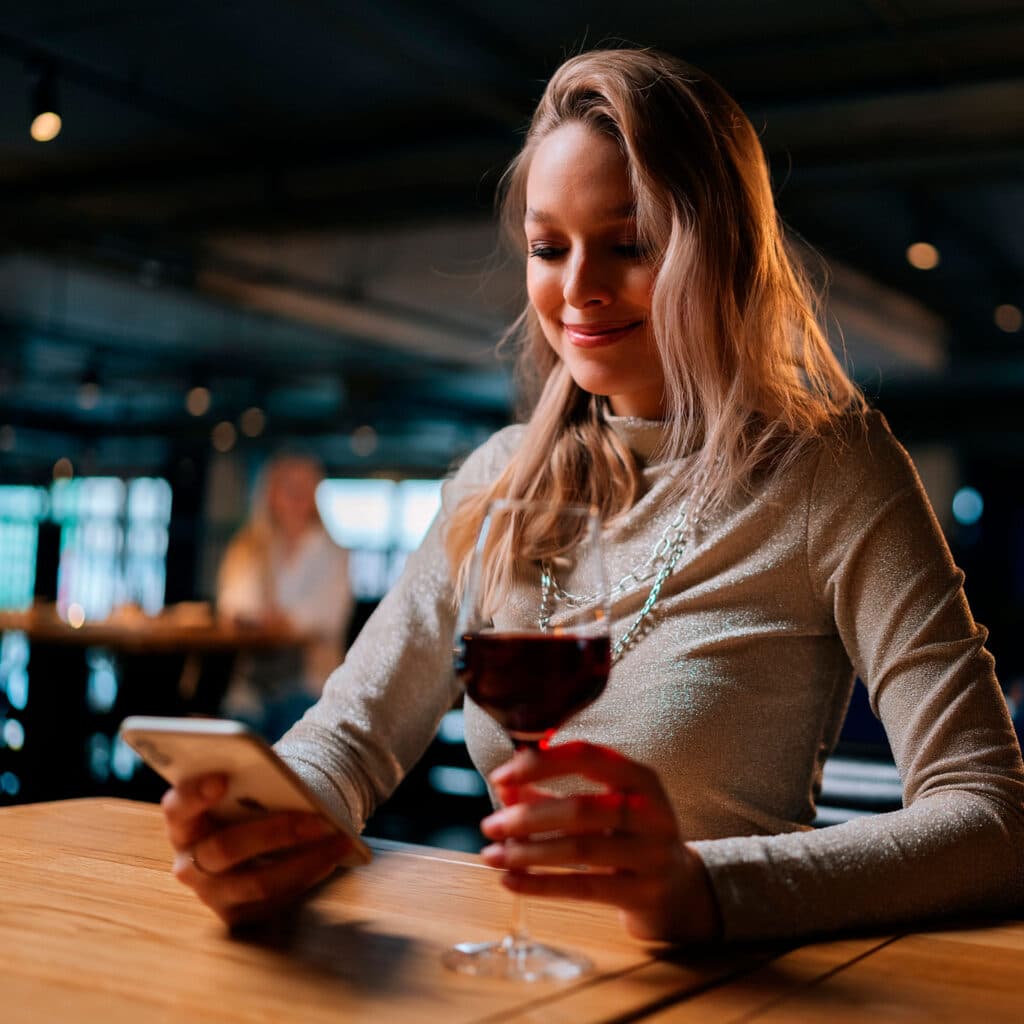 Persona disfrutando del vino con la app Vinok
